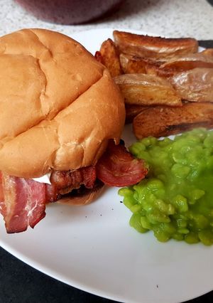 A picture of My Mega Chicken Burger with potato wedgies and mushie peas. 😁.