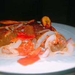 A picture of Pomo with fried plantain and sauce.