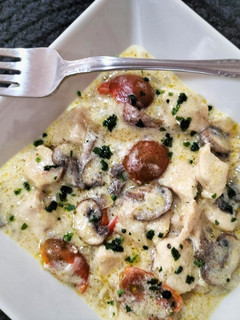 Una foto de Pollo con champiñones y cherrys en salsa bechamel