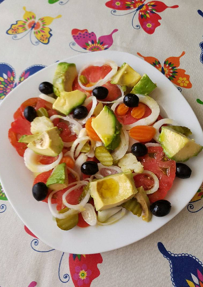 Una foto de Ensalada de tomate, cebolla, encurtidos, cebolla y olivas negras