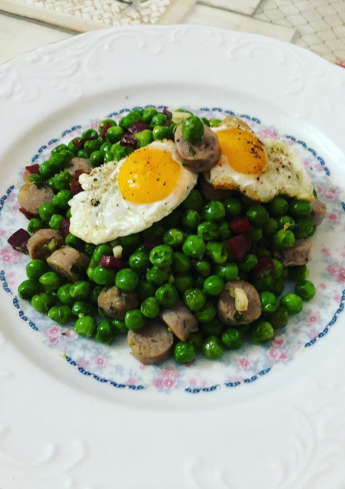 Una foto de Guisantes salteados con jamón, huevos de codorniz y salchichas