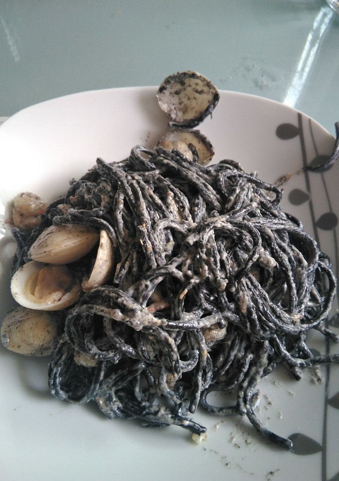 Una foto de Espaguetis negros con gambas y almejas