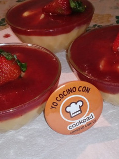 Una foto de Postre de crema con salsa de frutilla🍓🥣