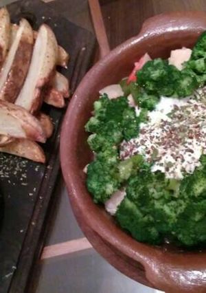 Una foto de Brócoli en colchón de pollo, con papas en salsa de palta