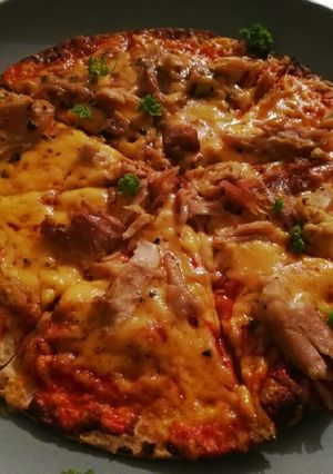 A picture of Tortilla base chicken & tomato pizza.