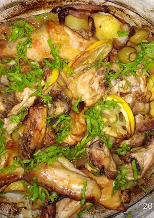 A picture of Baked chicken with lemon, potato and green olives.