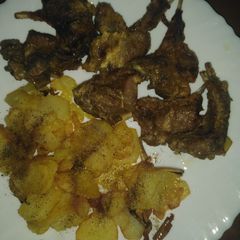 A picture of Mutton chops with fried potatoes.