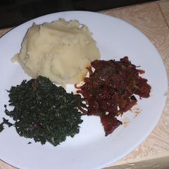 A picture of Pork with mashed potatoes served with spinach.