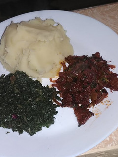 A picture of Pork with mashed potatoes served with spinach.