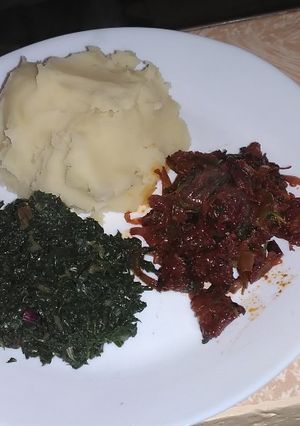 A picture of Pork with mashed potatoes served with spinach.
