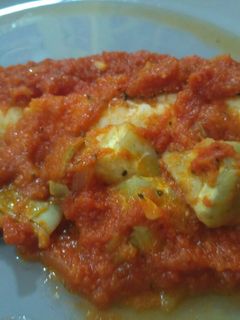 Una foto de Merluza al horno con tomate y alcachofas