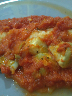 Una foto de Merluza al horno con tomate y alcachofas