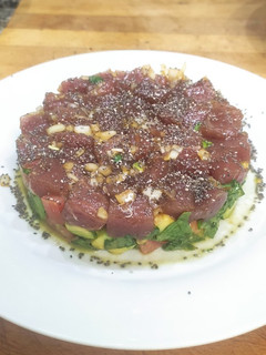 Una foto de Tartar de atún con aguacate, tomate, cebolla y espinacas