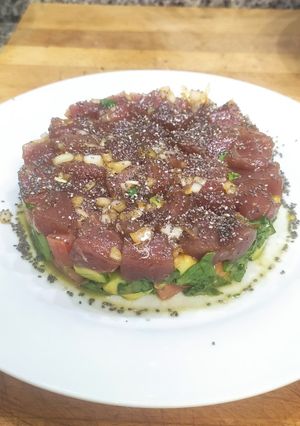 Una foto de Tartar de atún con aguacate, tomate, cebolla y espinacas