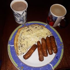 A picture of Plain omelette and deep fried sausages.