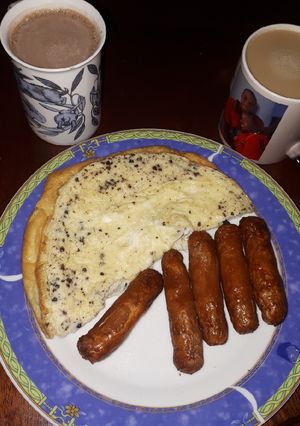 A picture of Plain omelette and deep fried sausages.