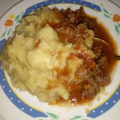 A picture of Mashed bananas with beef stew.
