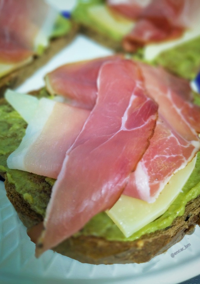 Una foto de Tostada de guacamole con queso tostado y jamón ahumado