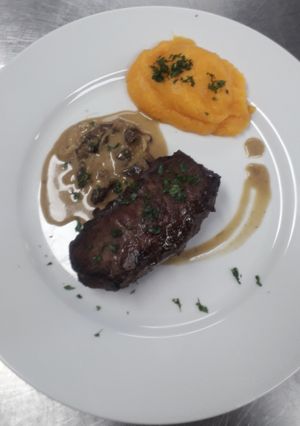 Una foto de Entrecôte Asado con Crema de Hongos y Puré de Calabaza