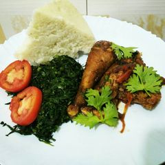 A picture of Wet fried chicken with greens and ugali.