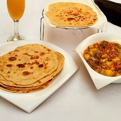A picture of Garlic naan bread with Beef and veggies soup.