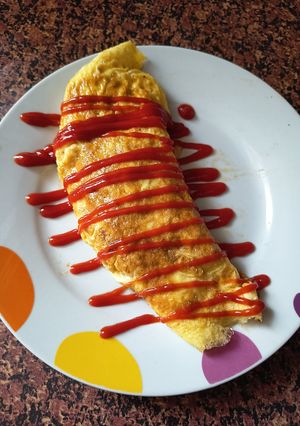 Una foto de Omurice (Tortilla Japonesa rellena de arroz frito)