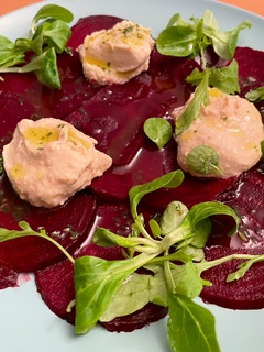 Una foto de Carpaccio de remolacha con hummus y rúcula al toque de albahaca