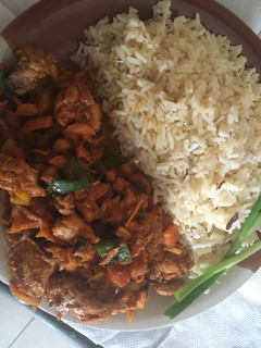 A picture of White coconut rice paired with carrot sauce and chicken.