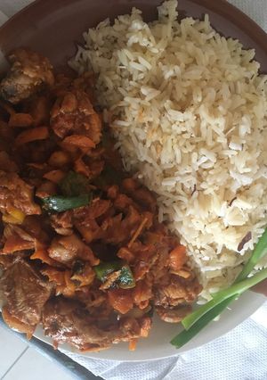 A picture of White coconut rice paired with carrot sauce and chicken.