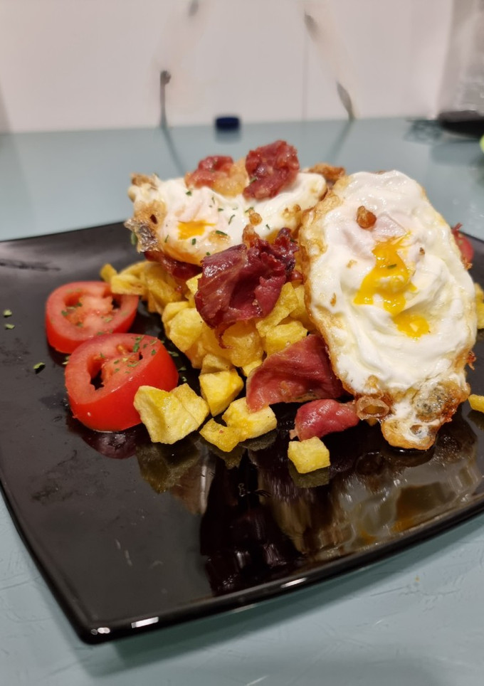 Una foto de Huevos rotos con jamón