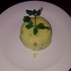 A picture of Mashed potatoes with peas.