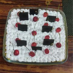 A picture of Fruit Custard pudding with white cream.