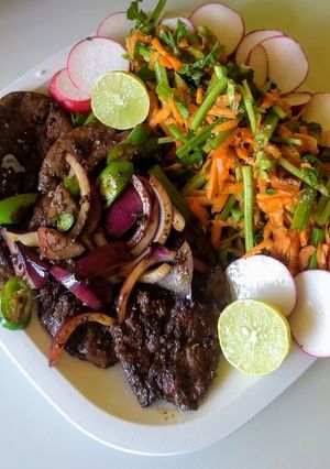 Una foto de Hígado encebollado con ensalada de berros