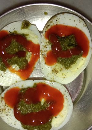 A picture of Boiled eggs with tomato sauce.