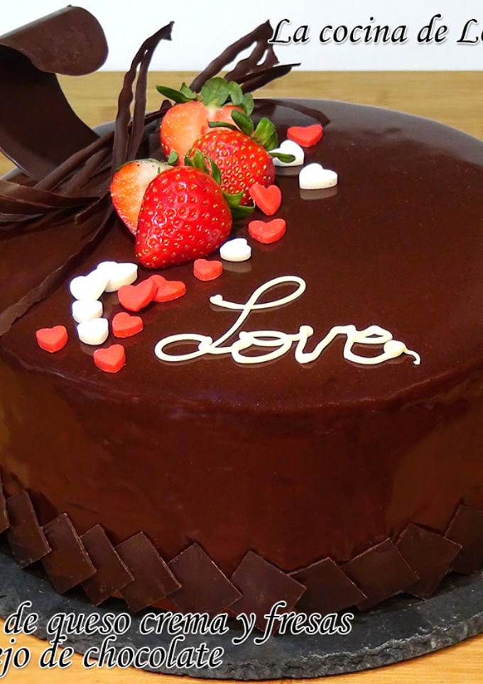 Una foto de Tarta de mousse de queso crema y fresas con baño espejo de chocolate y decorada para San Valentín
