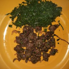 A picture of Fried beef with greens.