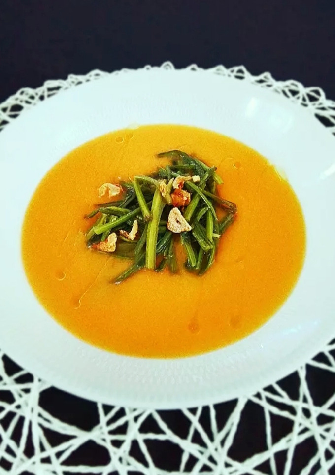 Una foto de Crema de calabaza con salteado de tallos de espinacas