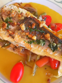 Una foto de Lubina rellena de verduras sobre crema de espárragos