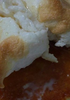 Una foto de Esponja de vainilla sobre salsa de tres leches anisada coronada con merengue suizo horneado salpicado de caramelo