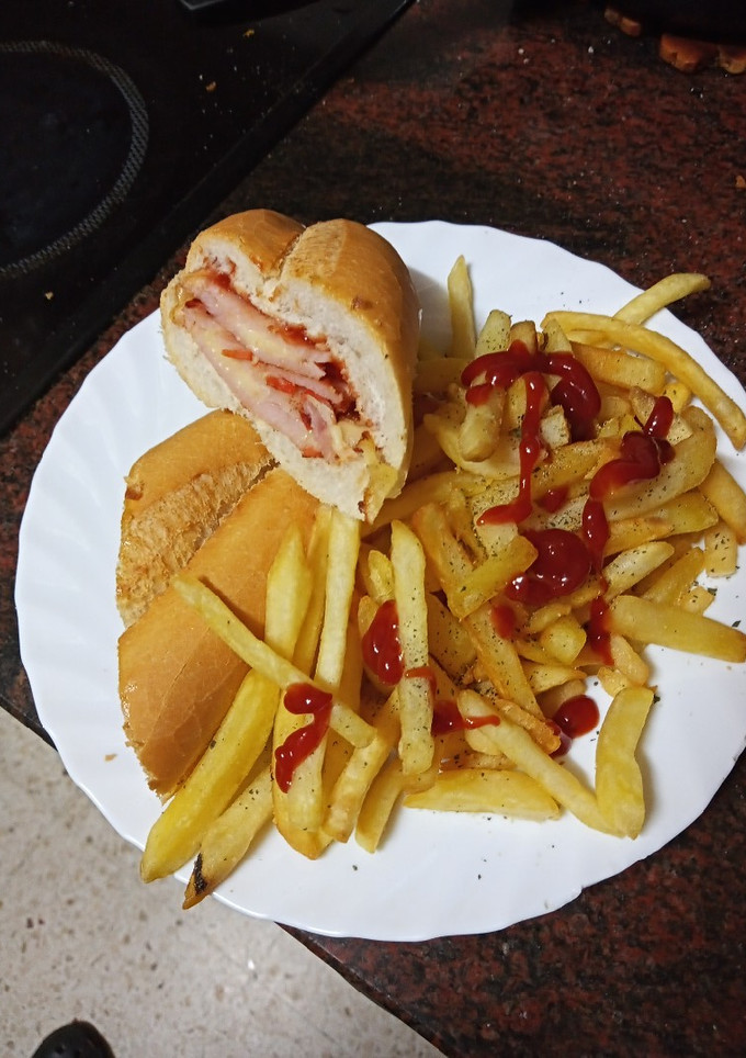 Una foto de Bocadillo de lomo adobado con queso y cebolla frita con papas