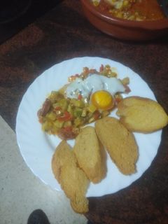 Una foto de Huevos al plato con chorizo y peinetas de pan