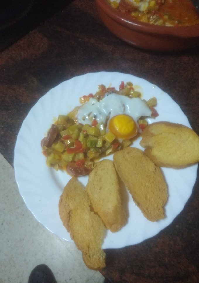 Una foto de Huevos al plato con chorizo y peinetas de pan