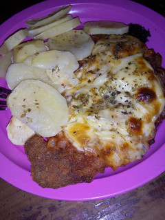Una foto de Milanesa napolitana y papas al horno