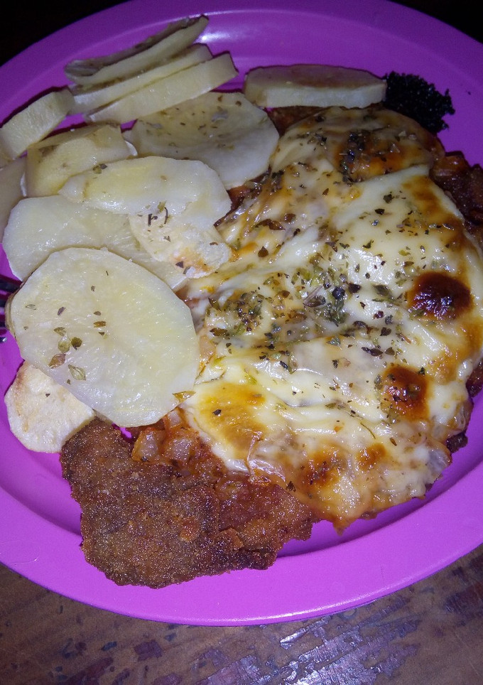 Una foto de Milanesa napolitana y papas al horno