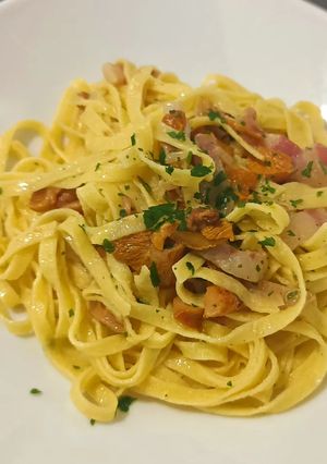 A picture of Tagliatelle with chanterelle mushrooms and guanciale.