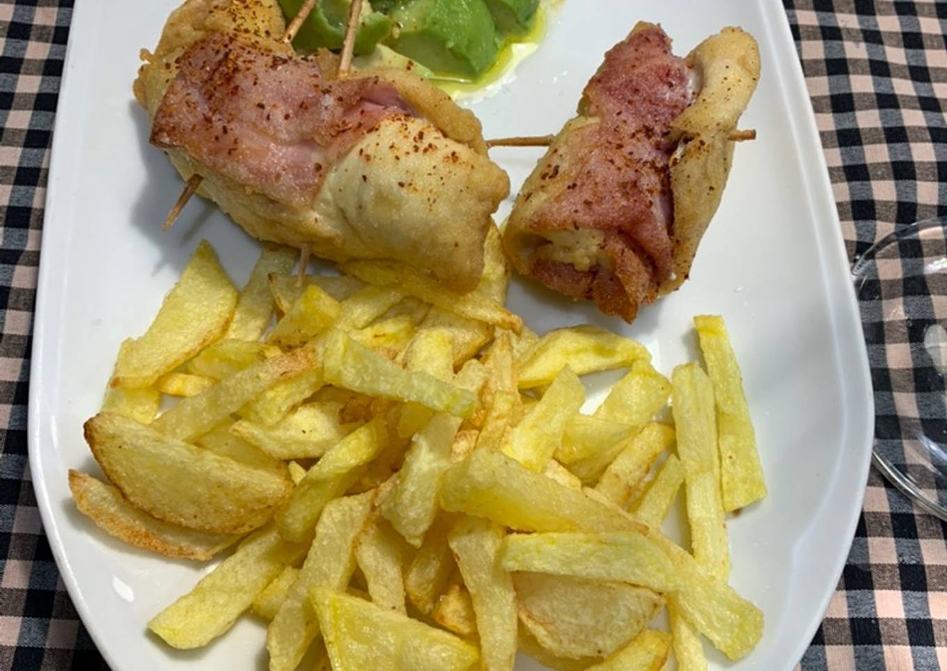 Rollitos de pechuga de pollo, jamón York y foie acompañado de aguacate y patatas fritas