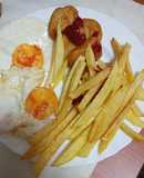 Nuggets de pollo con un par de huevos fritos y papas
