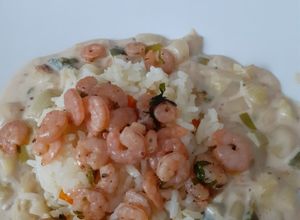 Una foto de Camarones con arroz y salsa blanca