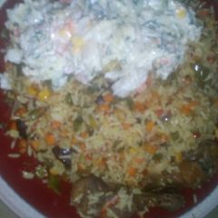 A picture of Fried rice served with vegetable salad and fried chicken.