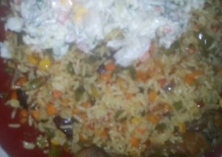 Fried rice served with vegetable salad and fried chicken